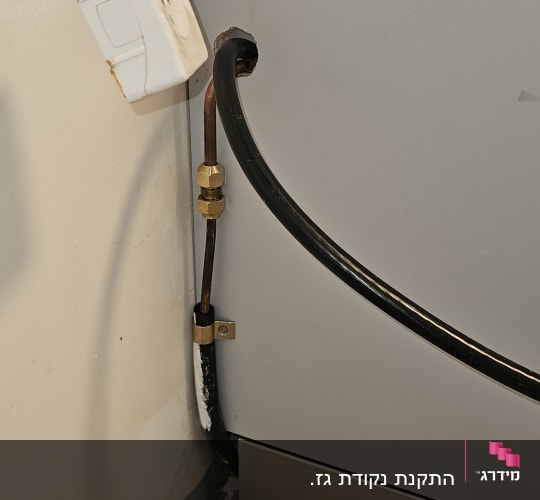 צינור גז מחובר לקיר ליד מכשיר חשמלי